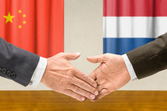 Vertreter Chinas und der Niederlande reichen sich die Hand