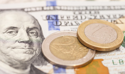Euro coins over dollar notes
