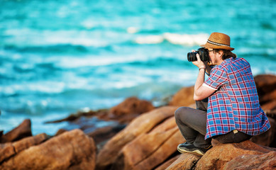 Young photographer taking photos at the beach 