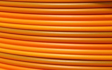 coils of orange plastic pipes for the installation of undergroun