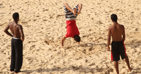 Chicos haciendo gimnasia en la playa