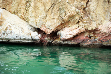 The mountainous terrain of the Indian Ocean coast. Mountains fit close to the water. Water is a beautiful greenish-blue color. Photographing in late autumn.
