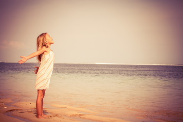 Fototapeta na wymiar Happy Little girl standing on the beach