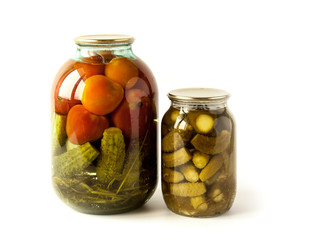 Salted cucumbers and tomatoes in glass jars isolated on white