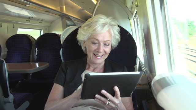 Businesswoman Commuting On Train Using Digital Tablet

