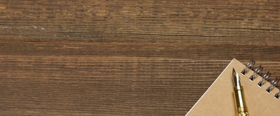 Fototapeta premium Notepad With Real Gold Fountain Pen On The Old Rough Wooden Table Background