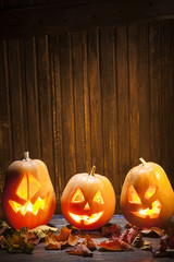 Jack o lanterns Halloween pumpkin face on wooden background