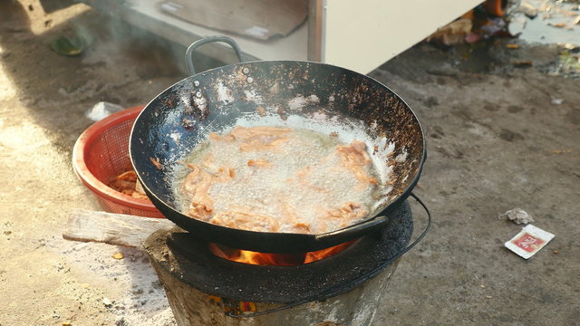 Deep-frying bullfrogs in a wok over a household stove ( close up )	