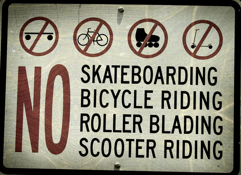 aged and worn vintage photo of sign prohibiting skateboarding