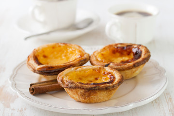 portuguese cookies on white dish with cup of coffee