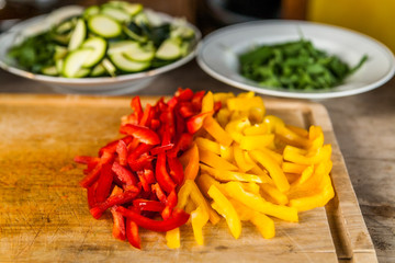 Gelbe und rote Paprika auf Küchenbrett