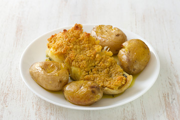 fried fish with potato and oil on dish on white background