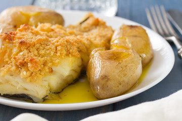 fried fish with potato and oil on white dish