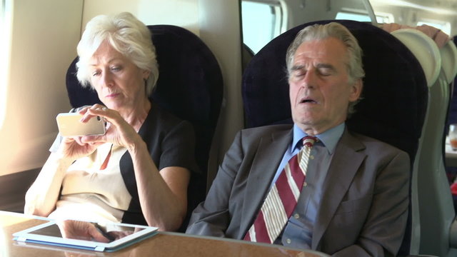 Two Senior Businesspeople Commuting On Train
