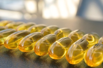 Omega 3 fish oil gel capsules on the black table. Food supplements; essential fatty acids; healthy diet.