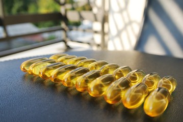 Omega 3 fish oil gel capsules on the black table. Food supplements; essential fatty acids; healthy diet.