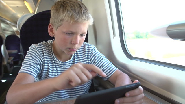 Boy Reading E Book On Train Journey
