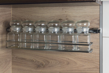 Glass spice jars on a shelf. Kitchen interer