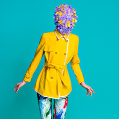 Fashion model in yellow coat and art accessories posing in the