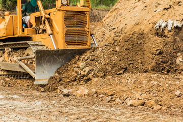 Fototapeta na wymiar industrial bulldozer moving earth and sand in sand pit or quarry