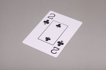 Two of clubs playing card on gray background