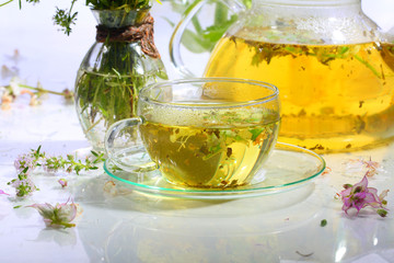 Medical tea with fragrant grasses in a transparent cup