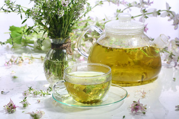Medical tea with fragrant grasses in a transparent cup