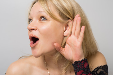 Overhears a woman put her hand to ear