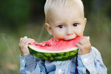 little boy eats watermelon