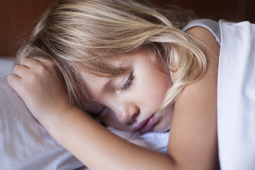 Fototapeta premium Adorable little girl sleeping in a bed 