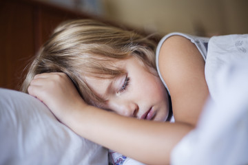 Obraz na płótnie Canvas Adorable little girl sleeping in a bed 