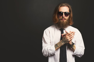 Close up stylish gorgeous young  businessman with long beard with glasses on black background