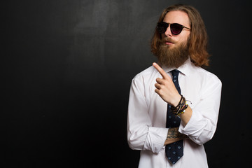 Close up stylish gorgeous young  businessman with long beard with glasses on black background