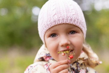 child eating fun wild strawberry twig holding hand shallow DOF