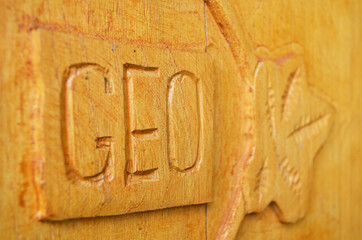 geo word written on the wooden plank and leaf on the side