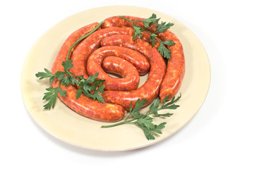 Fresh raw sausages on plate isolated on white