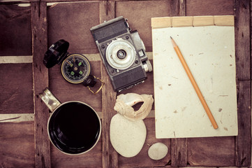 cup of coffee with compass notepad and camera