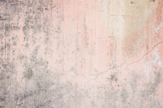 Worn pale pink concrete wall texture background with a bit of vignetting, paint partly faded.