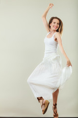 Naklejka premium Woman in summer white dress jumping