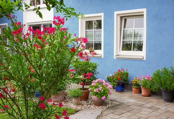 Fototapeta na wymiar blaue Hausfront mit mediterraner Blumendekoration