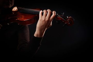 Violinist playing violin on dark background © Africa Studio
