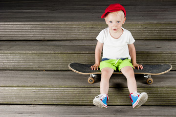 Boy sitting on a skateboard