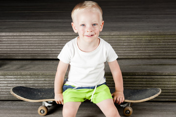 Boy sitting on a skateboard