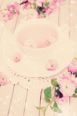Cup of tea and beautiful fruit blossom on table