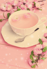 Cup of tea and beautiful fruit blossom on table