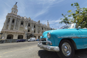Blue classic car in front of the National Theatre in Havana, Cuba.