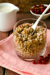Breakfest with buckwheat porridge, milk and red currant berries