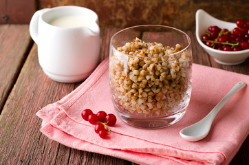 Breakfest with buckwheat porridge, milk and red currant berries