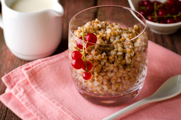 Breakfest with buckwheat porridge, milk and red currant berries
