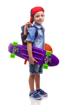 Portrait Of A School Kid Holding A Skateboard And A Basketball O